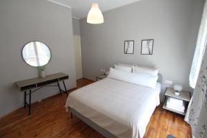 1 dormitorio con cama blanca y espejo en Newly Renovated Central 2 Bedroom Apartment in Kozani, en Kozani
