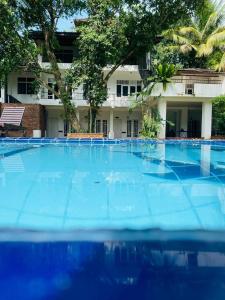 a large blue swimming pool in front of a building at The Shade Brothers in Katunayaka