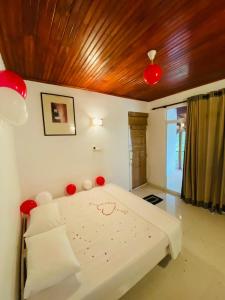 een slaapkamer met een bed met rode decoraties erop bij The Shade Brothers in Katunayaka