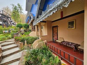 un edificio con portico, panchina e scale di Phu Jaya Floresta Resort by ALPHATEL a Chiang Mai