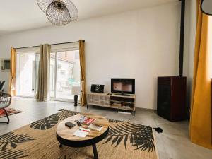 een woonkamer met een tafel en een televisie bij La Casita in Moltig les Bains