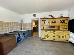 a kitchen with a stove and a large wooden cabinet at Egger's Sonnenhof Thurn in Thurn