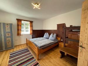 1 dormitorio con 1 cama y suelo de madera en Egger's Sonnenhof Thurn, en Thurn