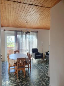 a dining room with a table and chairs at Fehér Rózsa Apartman in Cserszegtomaj