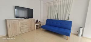 a blue chair in a living room with a tv at PISO CALPE - 2º LINEA in Calpe