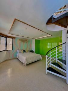 1 dormitorio con paredes verdes, 1 cama y una escalera en Hostal Panama Experience en Panamá