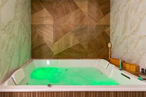 e bagno con vasca e acqua verde. di La Maison George a Flavigny-sur-Ozerain