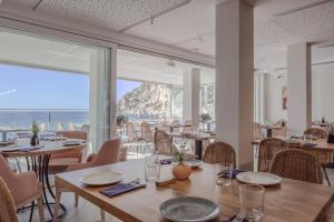 a restaurant with tables and chairs and a view of the ocean at Hotel La Cala Finestrat in Cala de Finestrat