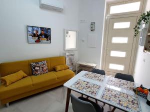 a living room with a yellow couch and a table at Casa Svea in Avola