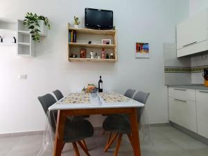 a kitchen with a table with chairs and a tv at Casa Svea in Avola +15 photos
