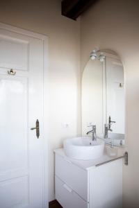 a white bathroom with a sink and a mirror at La Limonaia-charme & lake view in Meina