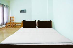a large white bed in a room with a table at OYO Assam Inn Grand in Guwahati