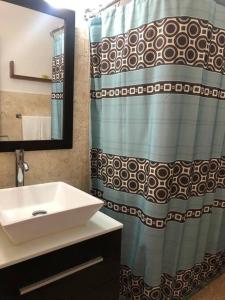 baño con lavabo y cortina de ducha en Cocomar Beach Studio, en San Juan