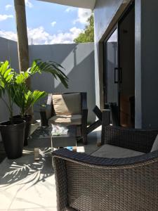 eine Terrasse mit Korbstühlen und einem Sofa in der Unterkunft Wang Residece in Lomé