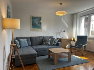 ein Wohnzimmer mit einem Sofa, einem Tisch und einem Stuhl in der Unterkunft Old Town 2-Bedroom Apartment Sienny Market Square by Stayly in Stettin