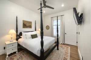 1 dormitorio con 1 cama y TV de pantalla plana en The Corner Brick House, en Covington