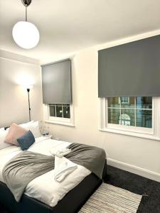 een slaapkamer met een bed en 2 ramen bij Room 4 • Double Bed in King’s Cross in Londen