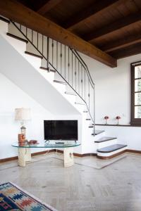 a living room with a television and a staircase at La Limonaia-charme & lake view in Meina