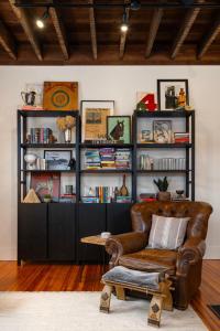 sala de estar con sofá de cuero y estante para libros en The Corner Brick House, en Covington