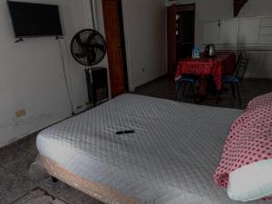 a bedroom with a white bed and a table and a tableablish at LA TRANQUERA DPTOs in Río Cuarto
