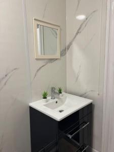 een witte badkamer met een wastafel en een spiegel bij Room 4 • Double Bed in King’s Cross in Londen