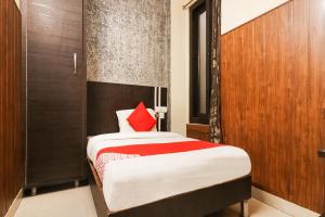 1 dormitorio con 1 cama con almohada roja en OYO Hotel Moonlight en Hisār