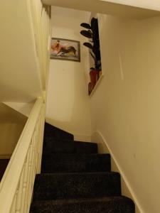 a staircase in a house with a picture on the wall at Convenient Luton Rooms in Luton