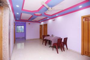 une salle à manger avec une table et des chaises et un plafond dans l'établissement OYO Raj Rajeswari, à Āsansol