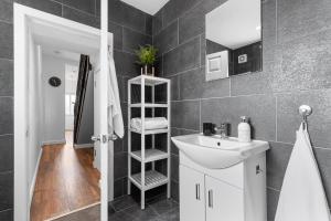 uma casa de banho com um lavatório branco e um espelho. em Luxury home-Sleeps 11-Central-Games-Free Parking em Southampton
