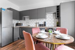 a kitchen with a wooden table and pink chairs at Luxury home-Sleeps 11-Central-Games-Free Parking in Southampton
