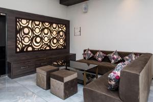 a living room with a couch and a tv at OYO Happy Home in Bhopal