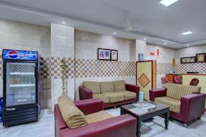 una sala de espera con sofás y una máquina de refrescos en OYO Hotel Radhakrishna, en Madurai