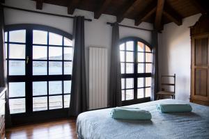 a bedroom with two pillows on a bed with windows at La Limonaia-charme & lake view in Meina