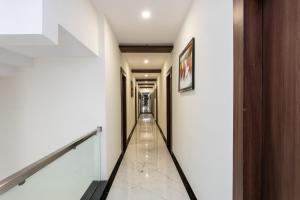 a corridor in a building with white walls and white floors at OYO Happy Home in Bhopal