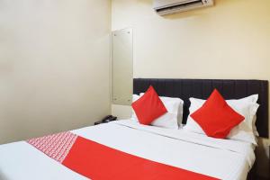 a bedroom with a bed with red and white pillows at OYO Hotel paradise in Mumbai
