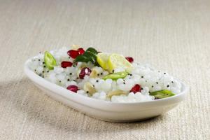 a white bowl filled with rice and vegetables on a table at OYO Happy Home in Bhopal
