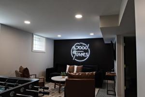 una sala de estar con un cartel de buenos tiempos en la pared en The Gilded Cincy-View Condo, en Covington
