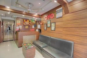 a waiting room with a leather couch and wooden walls at OYO Hotel Sion Residency in Mumbai