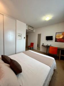 a hotel room with a large bed and a desk at Hôtel Jasses de Camargue in Gallargues-Le-Montueux