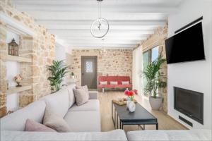 a living room with a white couch and a brick wall at Villa Valentina, Roumeli in Roumelí