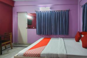 sypialnia z łóżkiem z kolorowymi ścianami i oknem w obiekcie OYO Balaji Inn w mieście Ballygunge