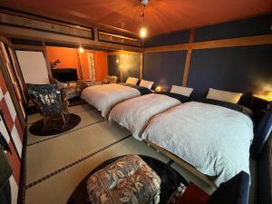 a room with two beds and a chair in it at とれるの【TORERUNO】 in Takayama