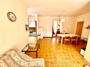 a living room with a table and a clock on the wall at Frau, grazioso trilocale in centro a Numana con spazio esterno in Numana