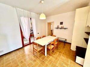 a dining room with a white table and chairs at Frau, grazioso trilocale in centro a Numana con spazio esterno in Numana