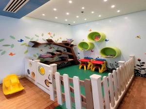 - une salle pour enfants avec une aire de jeux dotée d'une table et de chaises dans l'établissement Avery's Place @ One Eastwood Avenue, à Manille