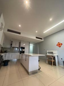 an empty kitchen with a table and a desk at Room 50Two, Itower Apartment, CBD, Gaborone in Gaborone