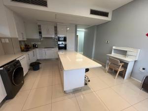 a large kitchen with a counter and a sink at Room 50Two, Itower Apartment, CBD, Gaborone in Gaborone +5 photos