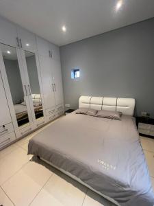 a bedroom with a large bed and two mirrors at Room 50Two, Itower Apartment, CBD, Gaborone in Gaborone