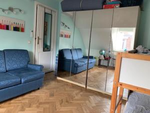 a living room with a blue couch and a mirror at Stay in maison de metre in Etterbeek in Brussels