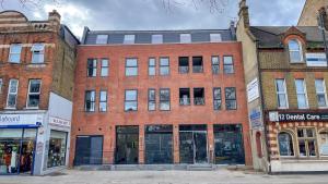 a red brick building on a city street at homely - North London Luxury Apartments Finchley in Finchley